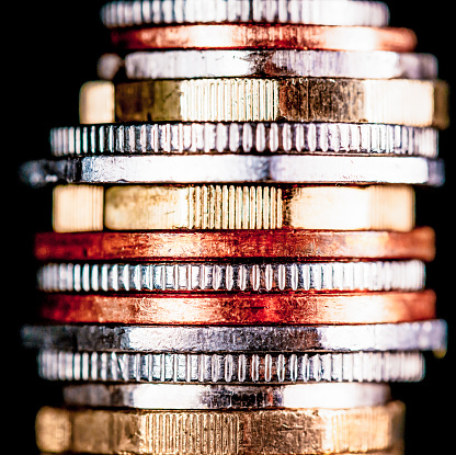 A macro image of a stack of coins on a black background.