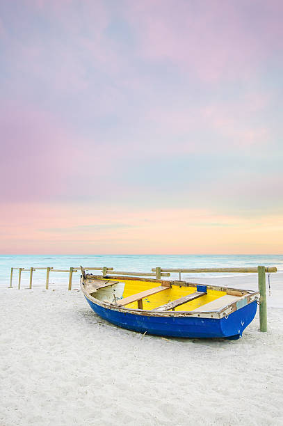 istock Old yellow blue wooden boat, white beach on sunset 160555190