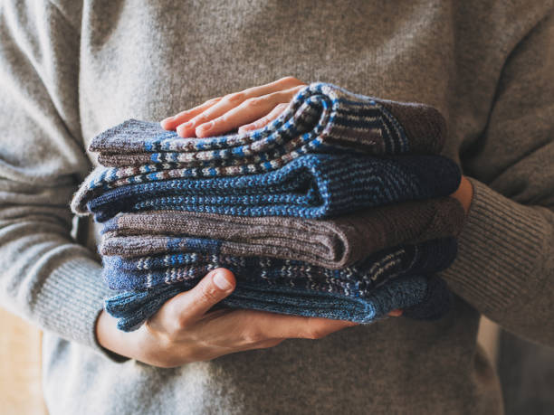 istock Cosy hand knitted socks in a female hands. Concept for handmade. 1605556297