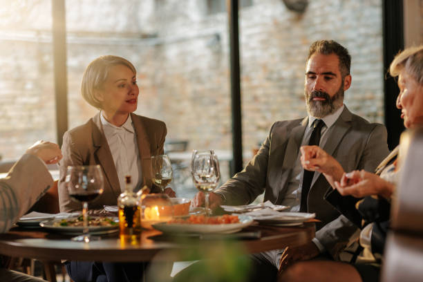 istock Businesspeople enjoying lunch together. 1605557364