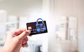 Close up of man hand holding credit or debit card with padlock, protection of financial transactions.