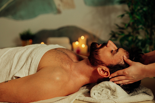 Man enjoying facial massage at spa