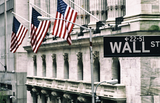 Wall street sign with New York Stock Exchange background. Lower Manhattan. Toned Image.