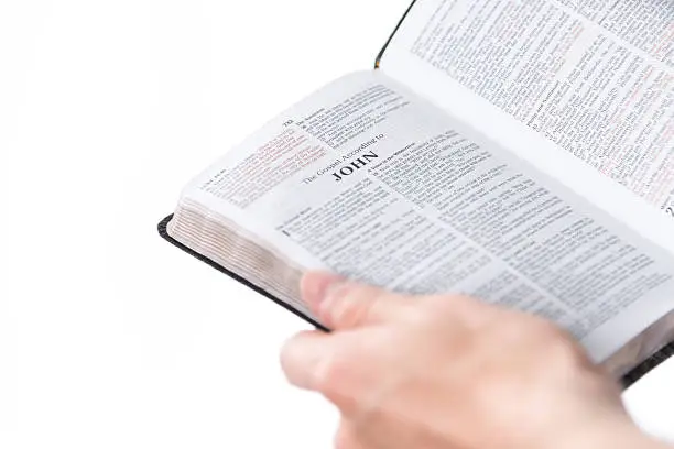Photo of Adult Male Holding Religious Text