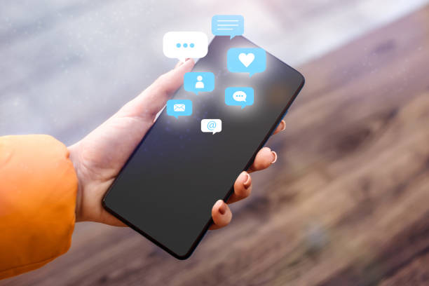 istock female hand holding and using a social media on mobile phone with notification icons 1605618565