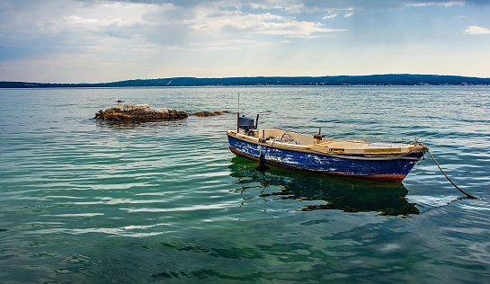 An old wooden boat on the Adriatic coast of Croatia at Kastel Kambelovac in Kastela. Late spring