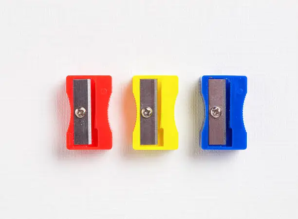 three different colors sharpener on white background