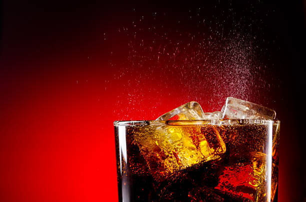 istock Glass cup of iced cola on red background 160562148