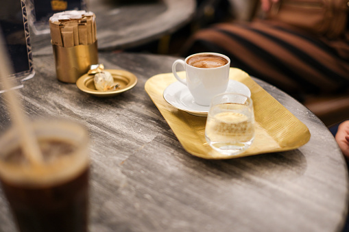 Image of frothy Turkish coffee on the table. There are two Turkish delights on the saucer stock photo