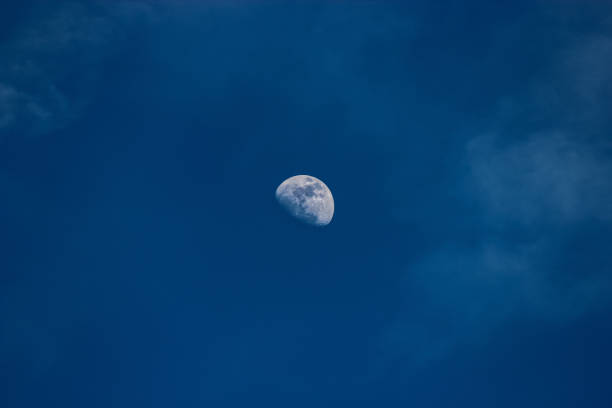 Half Moon in Blue Sky with Puffy Clouds