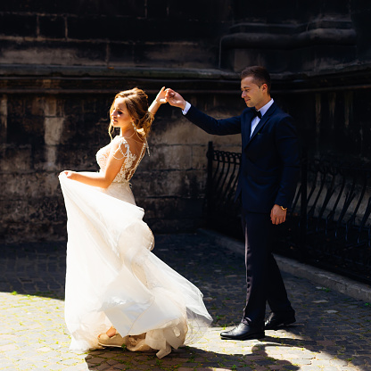 elegant and sensual dance of newlyweds near the wall on a beautiful sunny day