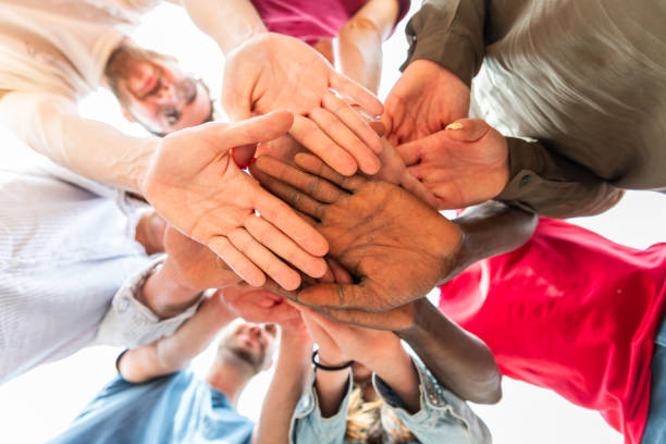 istock Hands in stack of multiracial young people  multiracial friends with hands in stack 1605636076