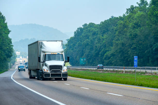 large white truck changes lanes on interstate highway - swerving imagens e fotografias de stock