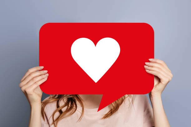 istock girl holding a like poster isolated over grey background 1605667482