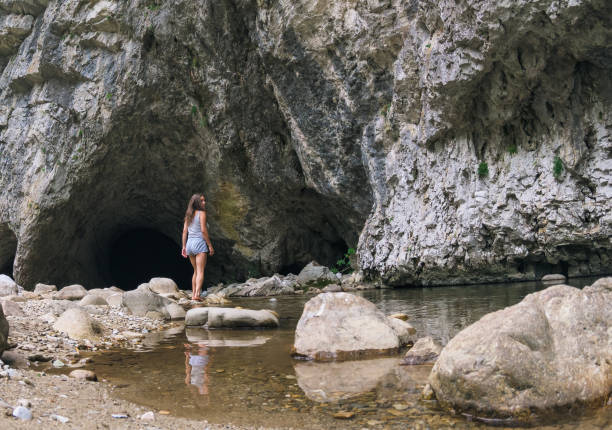 istock Caves, a mountain river and a woman. 1605685389