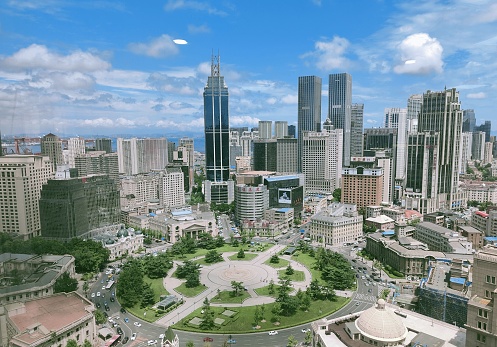 Aerial view of Dalian Zhongshan Square, featuring a cluster of high-rise buildings surrounded by lush green parks: Dalian, China