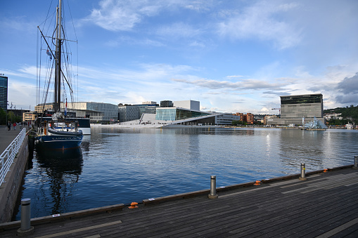Oslo, Norway, July 3, 2023 - The Oslo Opera House (Norwegian: Operahuset) in the background the Edvard Munch Museum.