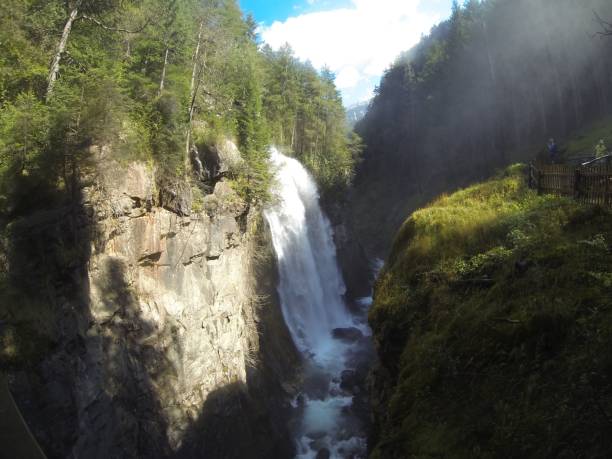 istock a very large waterfall flowing through a big canyon explorers through the canyon 1605709444