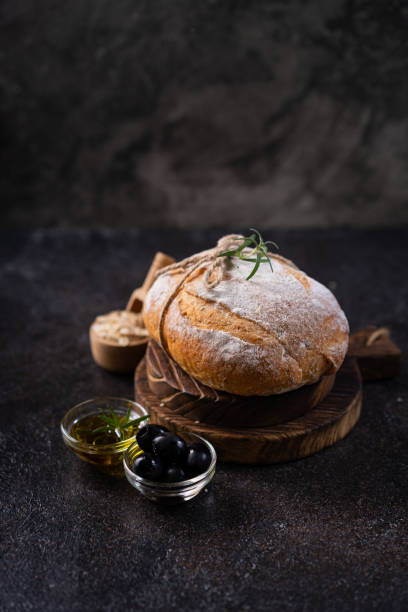 istock Fresh organic homemade artisan ciabatta bread on dark rustic background. sourdough bread 1605717480