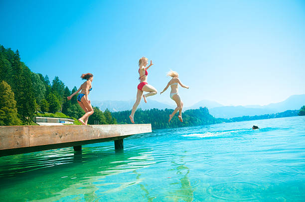 férias de verão com os seus amigos - arms outstretched teenage girls jumping flying imagens e fotografias de stock