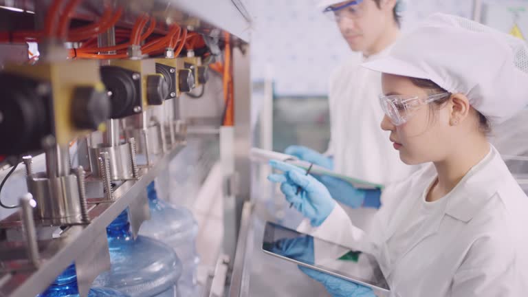 Employee check quality of product  in bottled pure  water factory.