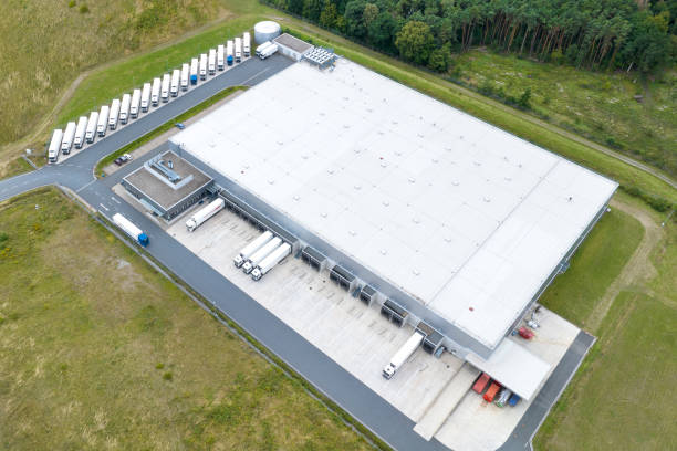 istock Loading bay, truck parking lot, unrecognisable industrial building, logistics - aerial view 1605772420