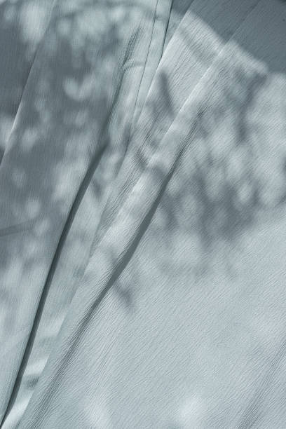 istock Aesthetic natural textile background with abstract sunlight shadow, neutral light blue draped fabric, copy space 1605805913