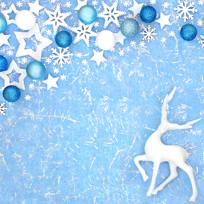 Christmas magical reindeer background with snowflake, star and bauble decorations on blue background. North pole fantasy happy holidays design for Yule, Noel, New Year.