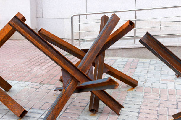 Anti-tank iron rusty hedgehogs on streets of modern city. Horrors of war, grief and loss