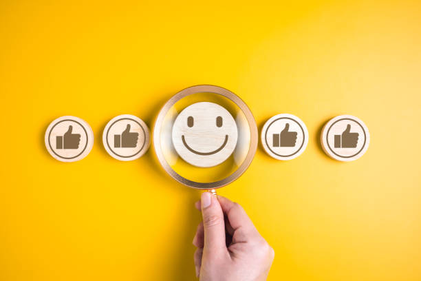 istock Hand holding magnifying glass with happy smile face emotion on blue background, Customer service evaluation, Positive thinking and mental health assessment, Happy client giving feedback with happiness 1605842254