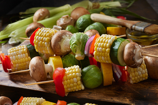Preparing Vegetable Kebabs with Corn on the Cob, Brussels Sprouts, Yellow and Green Zucchini, Mushrooms, Red Onions and Red Peppers