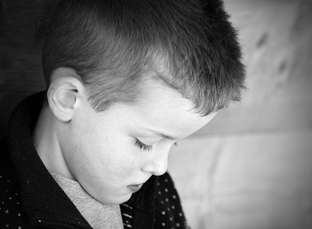 istock Depressed young boy looking down to the floor 160585569