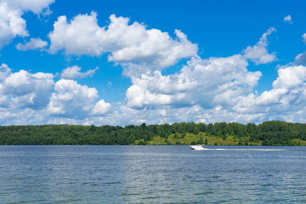 istock summer landscape with river, road and clouds in the blue sky 1605881565
