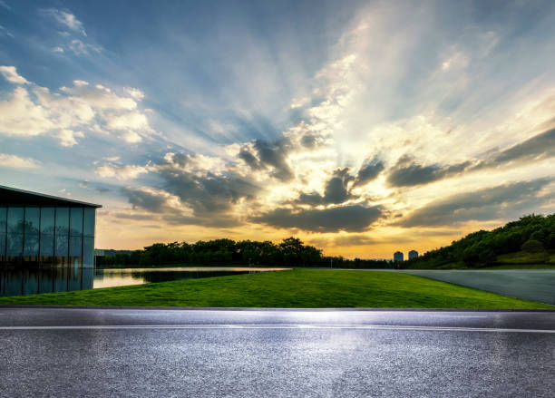 istock empty asphalt road in modern city with tyndall light in the sky during sunset. 1605888481