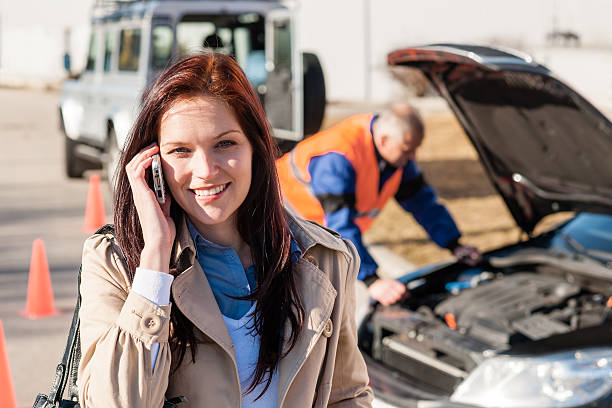 Woman talking on cellphone after car breakdown stock photo