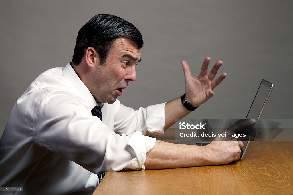 Computer crash Frustrated businessman having problem with his laptop on office desk 60-64 Years Stock Photo