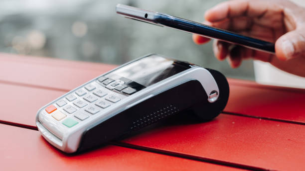 istock Person using contactless payment with smartphone. Mobile payment concept. Male using phone with NFC technology and POS terminal 1605919667