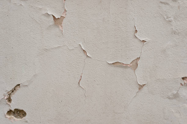 istock Antique architecture building facade detail. Authentic old ancient cracked neutral beige stucco plaster wall texture background 1605921821