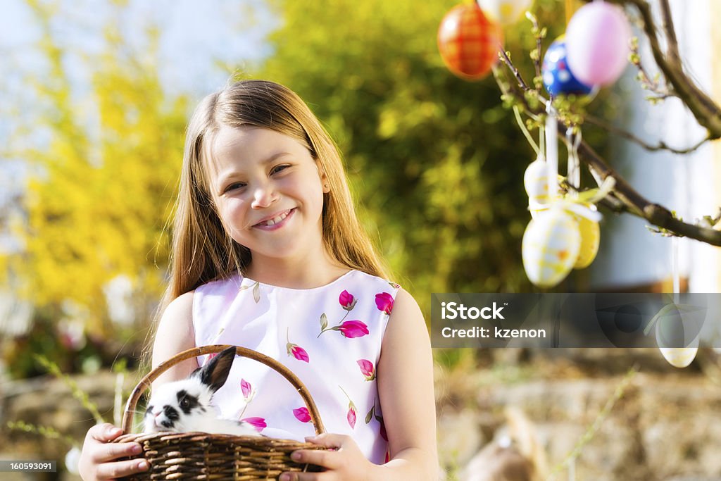 Enfant sur la chasse aux œufs de Pâques avec lapin - Photo de Avril libre de droits