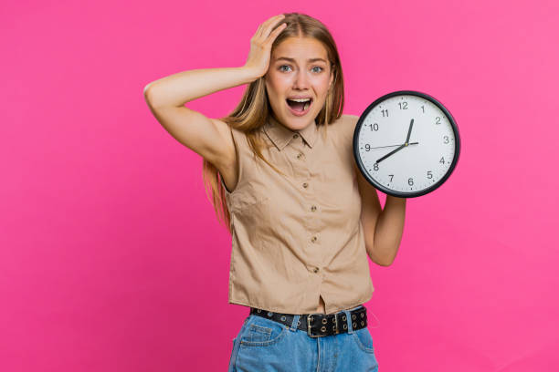 istock Young woman with anxiety checking time on clock, running late to work, being in delay, deadline 1605953632
