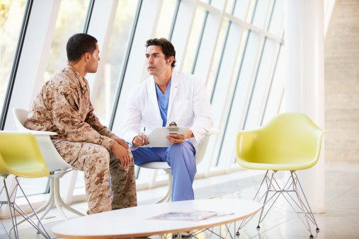 Male Doctor Counselling Soldier Suffering From Stress