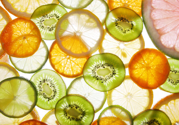Sliced citrus fruit cross sections on white background. Food background.