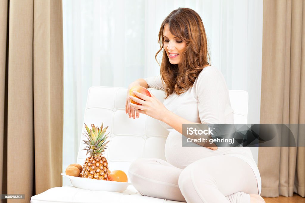 Прекрасный беременная женщина ест фрукты - Стоковые фото Беременная роялти-фри