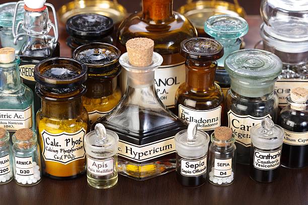 Various pharmacy bottles of homeopathic medicine Various pharmacy bottles of homeopathic medicine on dark background alchemy photos stock pictures, royalty-free photos & images