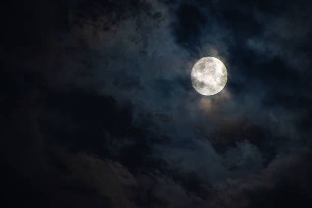 istock Full moon  in the clouds on a black sky 1605999298