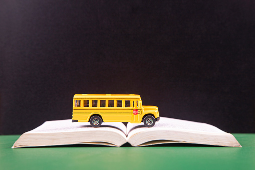 Yellow retro school bus on book