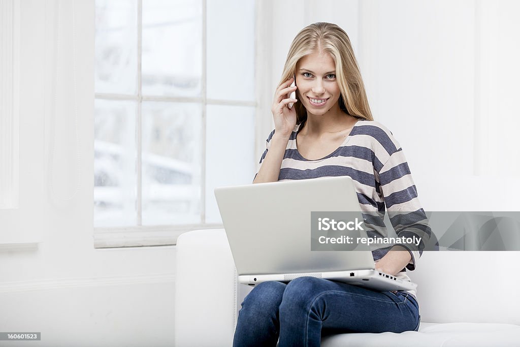 Hermosa rubia Joven mujer sentada en el sofá con el ordenador portátil - Foto de stock de 20-24 años libre de derechos