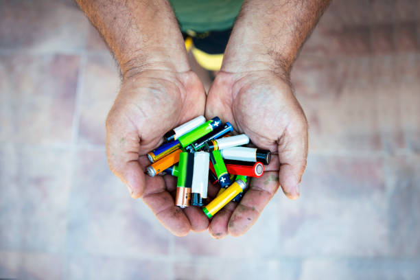 Old used batteries collected for recycling isolated in white. Toxic waste recycling and ecology issues concept background. Selective focus