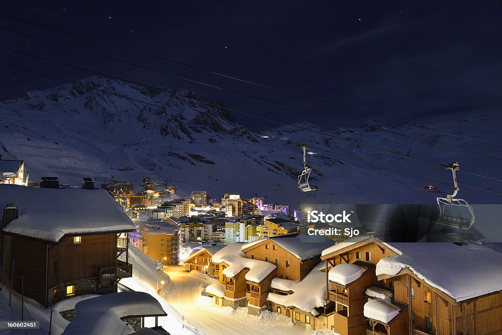 Val Thorens at night Night time view on the town of Val Thorens with empty streets and ski lifts. High mountain peaks with ski pistes in the background illuminated by moonlight. Ski Resort Stock Photo