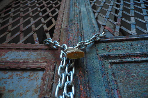 Closed old rusty lock on a wooden door.